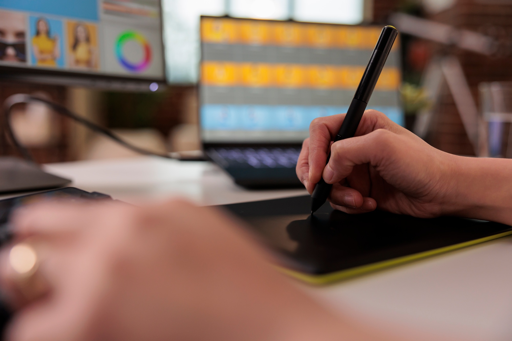 Retouching artist using stylus on graphic tablet